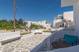 a balcony with two chairs and white buildings at Apollon Rooms in Pollonia