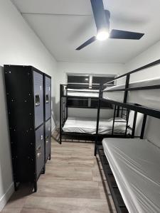 a room with three bunk beds and a ceiling fan at CG Miami House in Miami