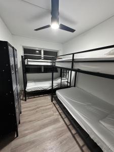 a room with three bunk beds and a ceiling fan at CG Miami House in Miami