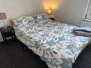 a bedroom with a bed with a floral comforter at Lovely Central Belfast 4 Bedroom Period Home in Belfast