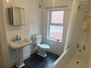 a bathroom with a toilet and a sink and a tub at Lovely Central Belfast 4 Bedroom Period Home in Belfast