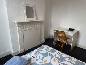 a bedroom with a bed and a desk with a mirror at Lovely Central Belfast 4 Bedroom Period Home in Belfast