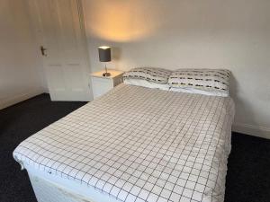 a white bed in a room with a lamp on a table at Lovely Central Belfast 4 Bedroom Period Home in Belfast +37 photos