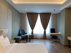 Hotel P4 City Center Jabalpur في جبلبور: غرفه فندقيه بسرير وكرسيين ونافذه