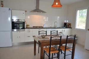 a kitchen with a table and chairs and a refrigerator at Villa Pepy in Salviac