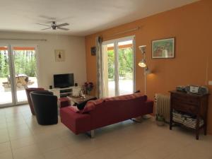 a living room with a red couch and a tv at Villa Pepy in Salviac