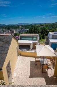 un patio con sombrilla y sillas y un edificio en Pensión Casa do Gallo Sarria, en Sarria