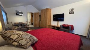 a hotel room with a red bed and a desk at Haus Aida in Saas-Fee