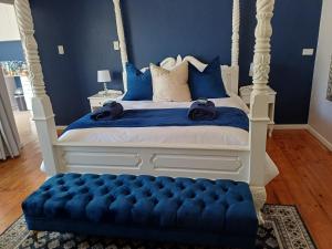 2 Seconds Avenue في هيلتون: غرفة نوم مع سرير المظلة والجدران الزرقاء