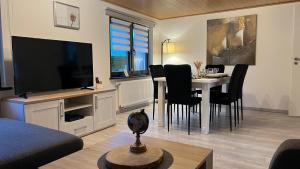 un soggiorno con tavolo da pranzo e televisione di Zum Rosenhügel a Hellenthal