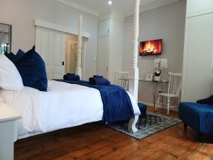 a bedroom with a white bed with blue pillows at 2 Seconds Avenue in Hilton