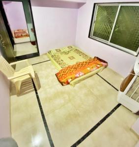 a room with a bed and a chair and a window at Shri Laxmi Villa in Akalkot