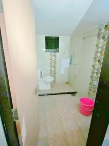 a bathroom with a toilet and a bucket at Shri Laxmi Villa in Akalkot