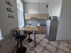 a kitchen with a wooden table and a refrigerator at Aurelija in Daugavpils