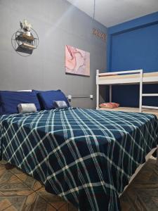 a bedroom with a bed with a blue and green blanket at Hope Hostel Praia do Morro in Guarapari