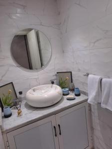 a white bathroom with a sink and a mirror at Haytam in Sale
