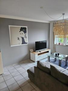 a living room with a couch and a tv at Design Wohnung in Petersdorf auf Fehmarn