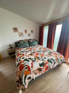 a bedroom with a bed with a colorful quilt at Chalet bois cosy indépendant Saint Jean de Niost in Saint-Jean-de Niost