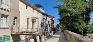 una calle en una ciudad con edificios y árboles en Quai n16 - Lieu atypique pour un séjour au calme, en Aramon