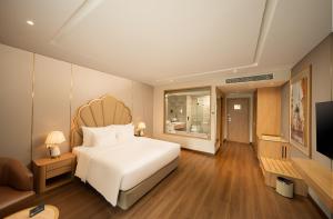 a bedroom with a large white bed and a couch at Anyla Grand Hotels in Thanh Hóa