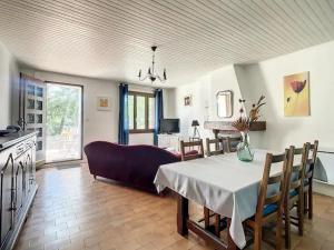 Una sala de estar con una mesa y una cocina. en Quai n16 - Lieu atypique pour un séjour au calme, en Aramon