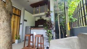 a kitchen with two stools and a counter with plants at Ametz Politak in Weligama