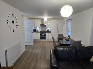 a living room and kitchen with a couch and a table at Stylish 2-Bed Flat with Open-Plan Living plus Parking in Edinburgh