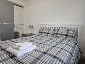 a bedroom with a bed with towels on it at Stylish 2-Bed Flat with Open-Plan Living plus Parking in Edinburgh