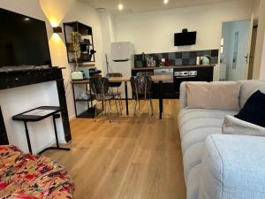 a living room with a couch and a table with chairs at Appartement standing 500m de la plage ! in Dunkerque