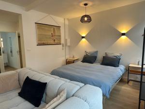 a living room with two beds and a couch at Appartement standing 500m de la plage ! in Dunkerque
