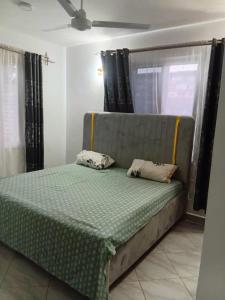 Una cama con dos almohadas encima en una habitación. en Kwa Engineer, en Wajir