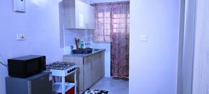 Una pequeña cocina con estufa y microondas. en Kwa Engineer, en Wajir