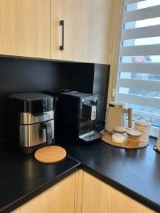 a kitchen counter with a coffee maker and a coffee pot at Apartament Przy Ratuszu in Malbork +8 photos