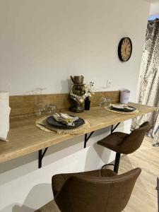 a table with wine glasses and a clock on the wall at Spa Sola in Mecquignies