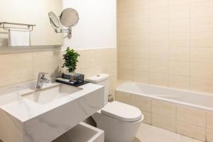 a bathroom with a sink and a toilet and a bath tub at كنكون - Cancun in King Abdullah Economic City