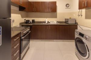a kitchen with a washing machine and a washer at كنكون - Cancun in King Abdullah Economic City +3 photos