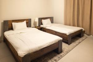 two twin beds in a room withskirts at كنكون - Cancun in King Abdullah Economic City