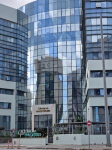 K2 Cliniques Jasmins Pasteur Cartagène في تونس: مبنى زجاجي طويل مع انعكاس لمبنى