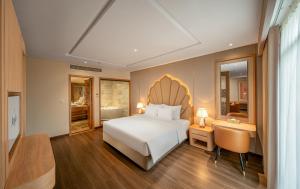 a bedroom with a bed and a desk and a chair at Anyla Grand Hotels in Thanh Hóa +12 photos