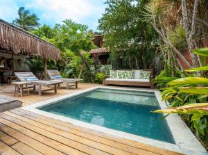 Casa e Pousada Alecrim في ترانكوسو: مسبح على سطح خشبي مع مقاعد ومنزل