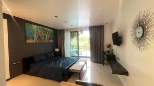 una camera da letto con un letto e un orologio sul muro di Cozy&callm a Patong Beach