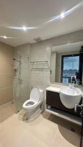 un bagno con un water, un lavandino e uno specchio di Cozy&callm a Patong Beach