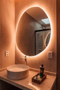 a bathroom with a round sink and a mirror at Pousada Aysú in Japaratinga