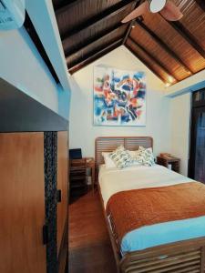 a bedroom with a bed and a painting on the wall at 3BR Villa mit Pool, Villa Jovino, Jameja Kerobokan in Kerobokan