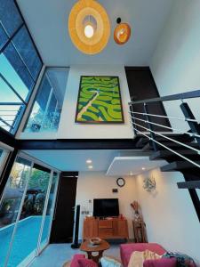 a living room with a spiral staircase and a television at 3BR Villa mit Pool, Villa Jovino, Jameja Kerobokan in Kerobokan +15 photos