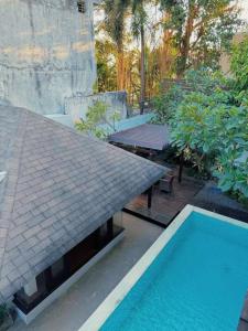 a swimming pool next to a house with a roof at 3BR Villa mit Pool, Villa Jovino, Jameja Kerobokan in Kerobokan