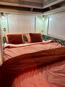 Una cama grande con dos almohadas encima. en Luxe caravan met rust, ruimte en uitzicht, en Saint-Sulpice-dʼExcideuil