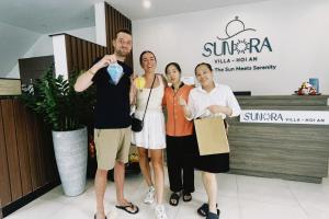 un grupo de personas posando para una foto en una tienda en Sunora Villa Hoi An, en Hoi An