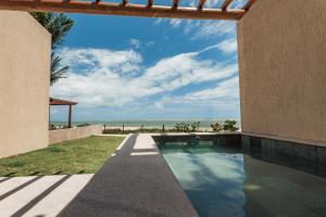 an external view of a house with a swimming pool and the beach at Pousada Aysú in Japaratinga