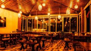 an empty restaurant with wooden tables and lights at Manthra Leisure in Kandy